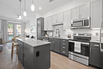 A kitchen with stainless steel appliances and white cabinets